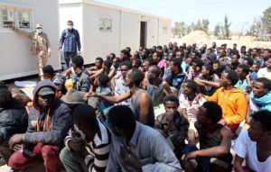 Migrants from sub-Saharan Africa sit at a center for illegal migrants in the al-Karem district of the Libyan eastern port city of Misrata on April 15, 2015, after their boat was intercepted by the Libyan coast guard. AFP PHOTO / MAHMUD TURKIA