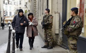 French policemen patrol on January 12, 2015 in Paris, in the Jewish quarter of the Marais district. France announced an unprecedented deployment of thousands of troops and police to bolster security at "sensitive" sites including Jewish schools Monday, the day after marches that drew nearly four million people across the country in tribute to the 17 victims of a three-day killing spree in Paris. The killings began on January 7 with an assault on the Charlie Hebdo satirical magazine in Paris that saw two brothers massacre 12 people including some of the country's best-known cartoonists and the storming of a Kosher supermarket on the eastern fringes of the capital which killed 4 local residents. AFP PHOTO / BERTRAND GUAY (Photo credit should read BERTRAND GUAY/AFP/Getty Images)